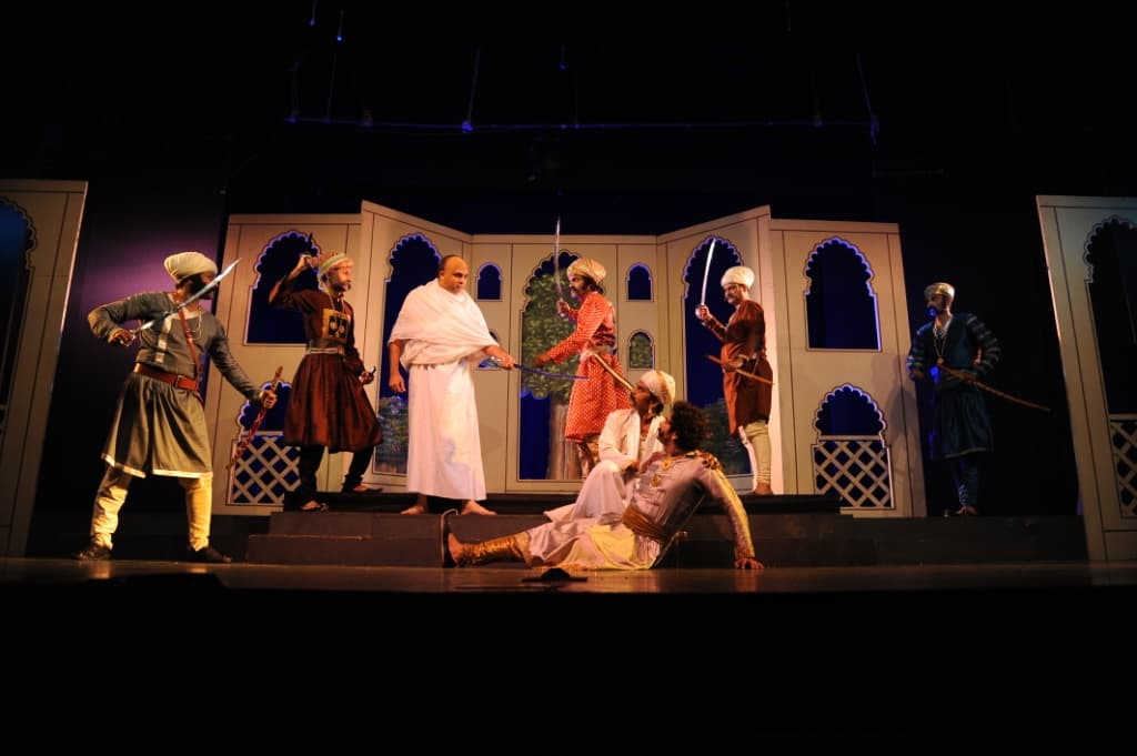 The full ensemble of Bhamasha on stage at NCPA — battle scene with Mughal-era sets